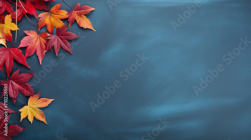 autumn background with colored red yellow leaves on blue background