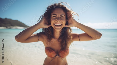 A Close up image of smiling woman in swimwear on the beach making a heart shape with hands - Pretty joyful hispanic woman laughing at camera outside - Healthy lifestyle.