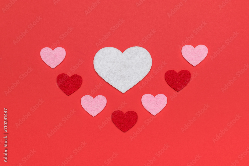 A pattern of carved hearts of various sizes on a red background.