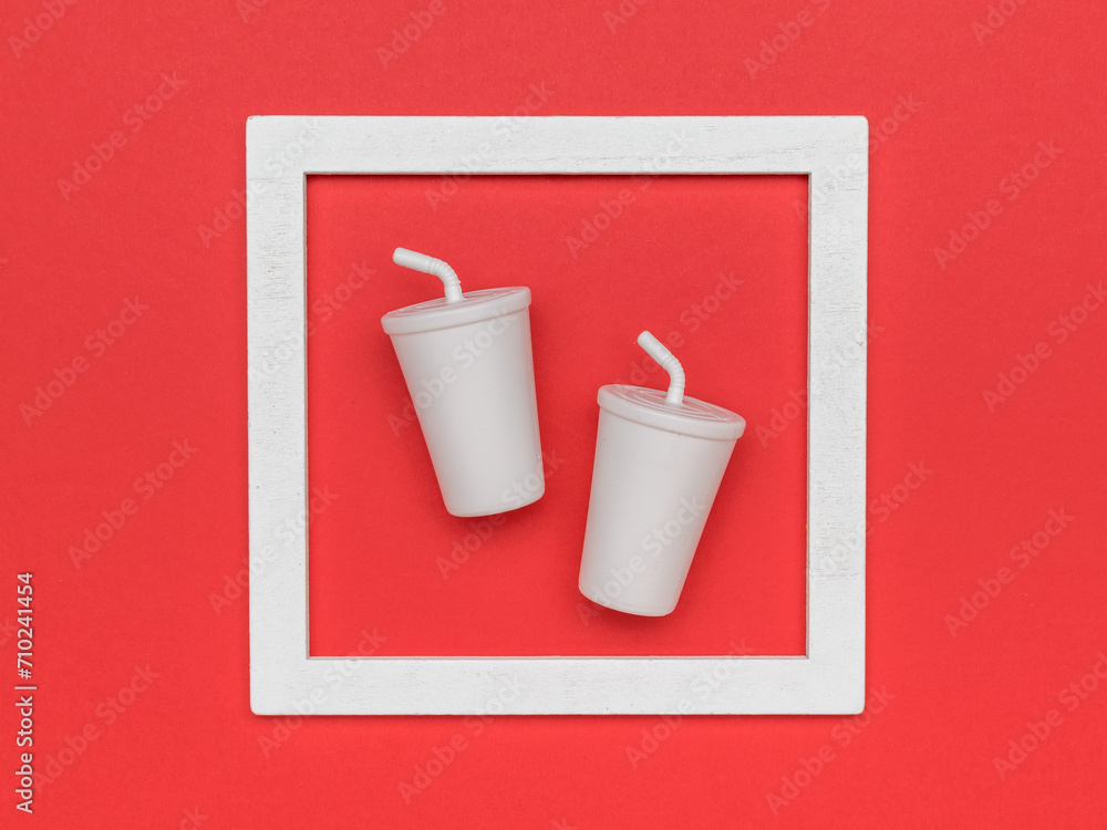 Fototapeta premium Two drinks glasses in a frame on a red background.