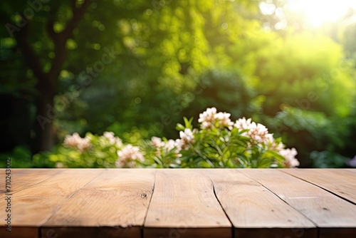 Product placement or montage featuring an empty wooden table in a sunlit summer garden with focus on the foreground table top against a white backdrop