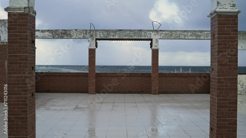 Seascape view through a building in ruins at twilight during rainy season in Phlippines, Asia photo