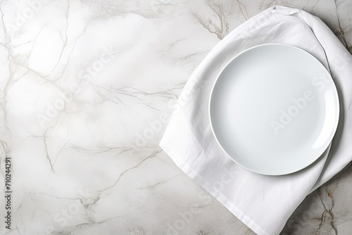 Top down view of white plate utensils and napkin on white stone table Empty space for duplication photo