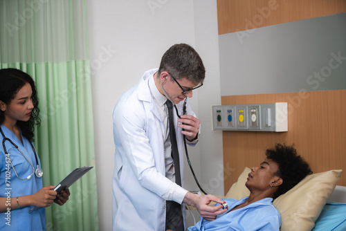Friendly doctor or physician doing medical checkup Young African American boy with stethoscope to chest and listens to his lungs and breathing sounds, testing and check up heart pulse at hospital ward