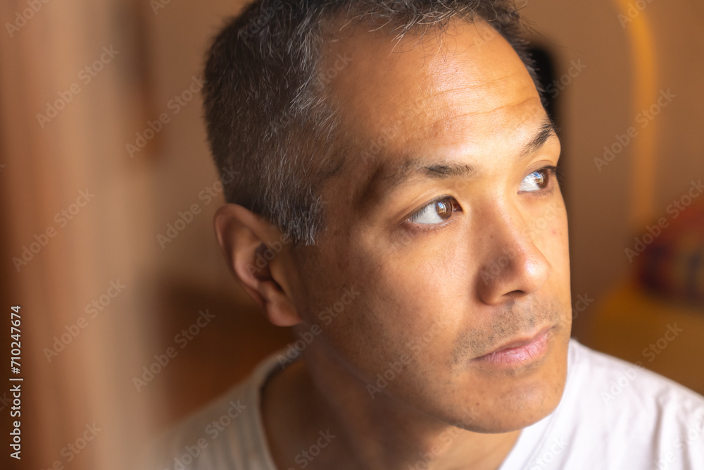 Portrait of sad Japanese young man looking at window. Portrait of sad Japanese young man looking at window.