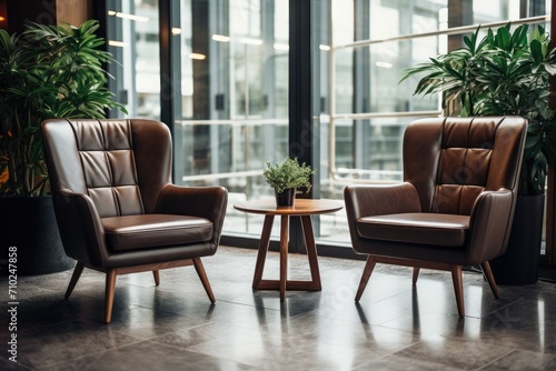 Two minimalist leather armchairs placed next to a coffee table in an elegant office or sleek apartment An open book agenda or planner sits on a meeting room ta photo