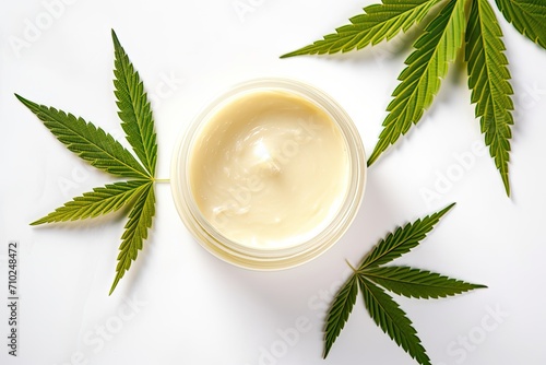 CBD cream and hemp leaves used in cosmetics for beautiful skin displayed on a white table photo