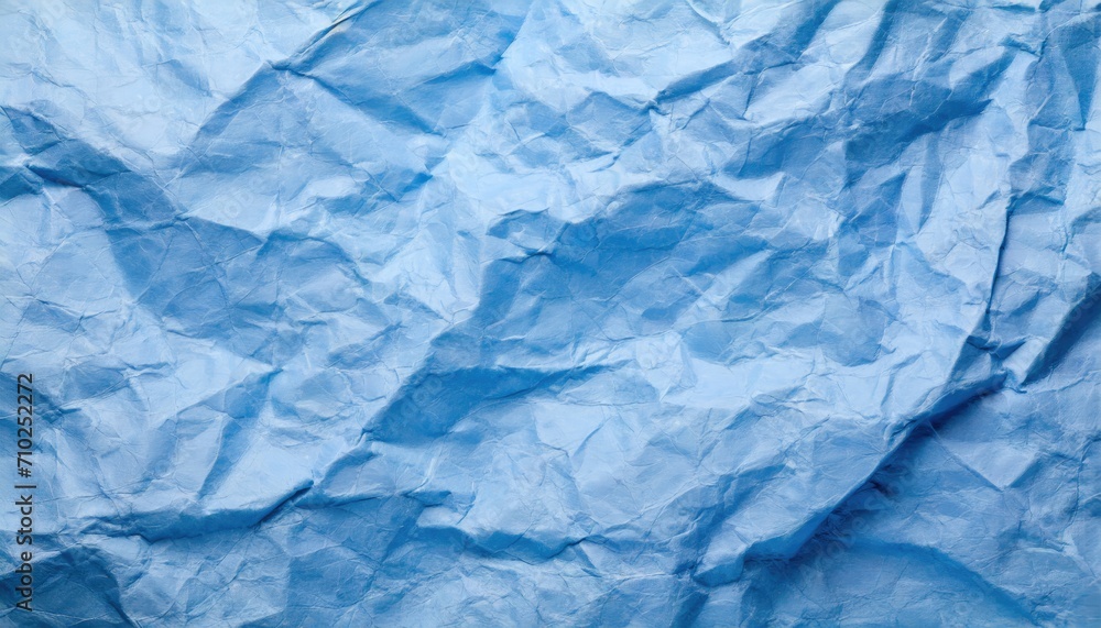 Obraz premium The blue crumpled paper background.