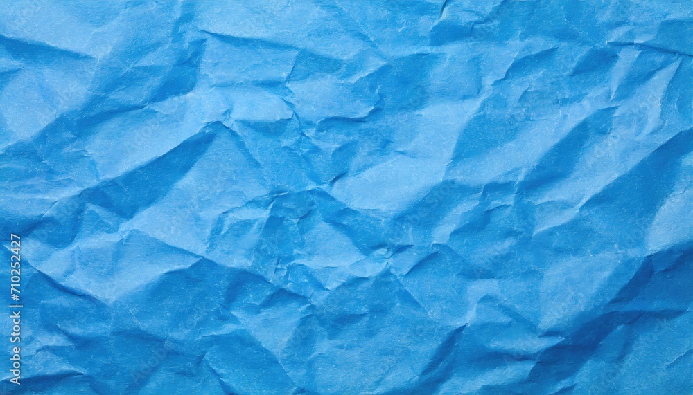 Obraz premium The blue crumpled paper background.