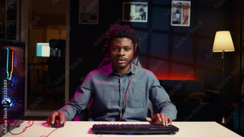 Annoyed gamer removing headphones in frustration raging losing mission while playing videogame on computer. African american man furiously yelling after failing to win level on PC game Annoyed gamer removing headphones in frustration raging losing mission while playing videogame on computer. African american man furiously yelling after failing to win level on PC game