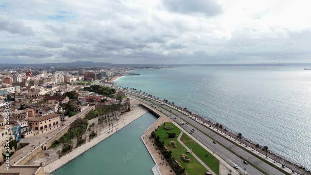 Aerial flight over coastal Road of Palma de Mallorca with traffic and bay during cloudy day, Spain Aerial flight over coastal Road of Palma de Mallorca with traffic and bay during cloudy day, Spain
