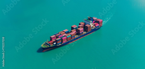 Aerial side view of cargo ship carrying container and running for export goods from cargo yard port to custom ocean concept technology transportation, customs clearance.