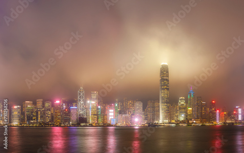 foggy night view of Victoria harbor in Hong Kong city