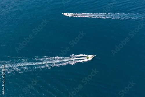 Two traffic flow of speedboats in the strait between tropical exotic islands, boats ply intensively carrying tourists. View from above top aerial