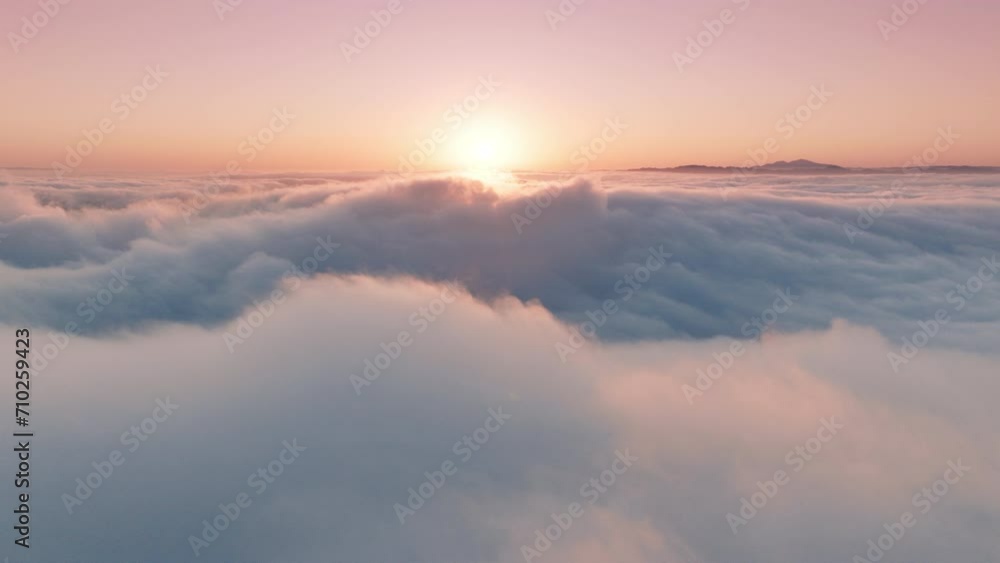 Epic aerial view over paradise cloudscape at sunrise or sunset. Wonderful inspirational sky with gentle pastel pink, peach and light blue clouds swirling fast below. Time lapse above beautiful clouds Epic aerial view over paradise cloudscape at sunrise or sunset. Wonderful inspirational sky with gentle pastel pink, peach and light blue clouds swirling fast below. Time lapse above beautiful clouds