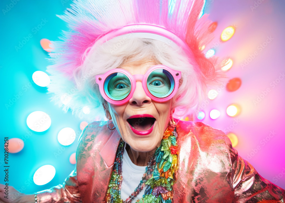 happy eccentric elderly woman in colorful clothes, hat and glasses, on multicolored background happy eccentric elderly woman in colorful clothes, hat and glasses, on multicolored background