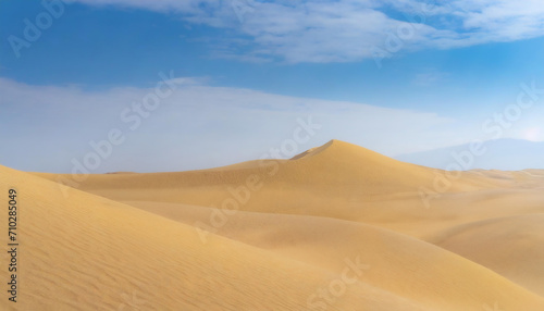  The image depicts a serene desert landscape with rolling sand dunes. The dunes are illuminated by the soft light of the setting sun, casting long shadows across the sand.
