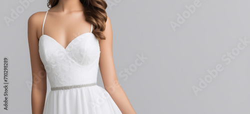 A positive beautiful woman in a white wedding dress laughing isolated in grey