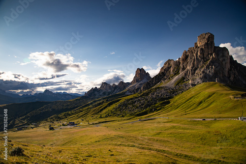 View of Ra Gusela mountain with green meadows and blue sky, Dolomites, Italy