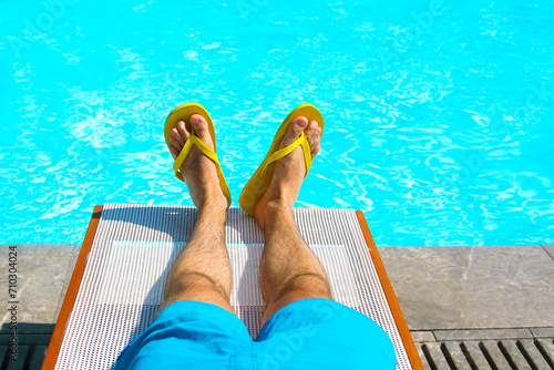 Young man lying on sunbed near pool. Summer vacation and travel concept photo