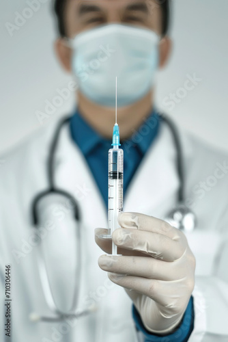 Close up of a doctor holding a syringe