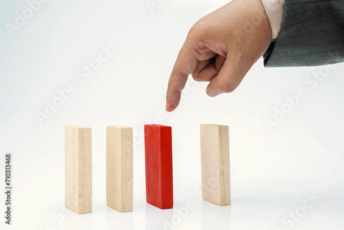 Business hand pointing a red wooden block in a row of brown wooden blocks