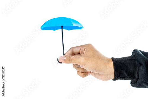 A human hand holding a small blue umbrella