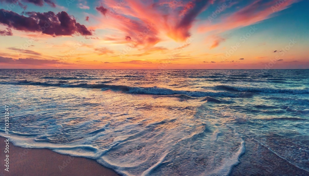 The endless sea to the horizon merges with the colorful sky at sunset.