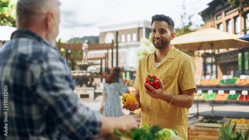 Portrait of a Young Handsome Customer Shopping for Organic Seasonal Fruits and Vegetables for a Healthy Breakfast. Multiethnic Man Buying Sustainable Bio Tomatoes From a Local Street Vendor
