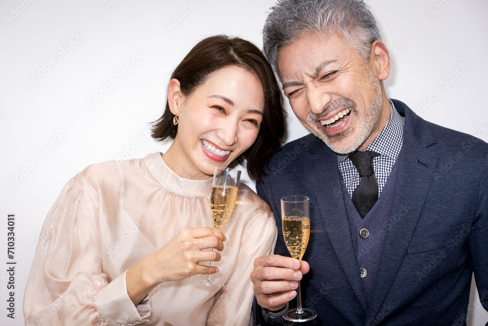 シャンパングラスを手に持ち記念日を祝う夫婦