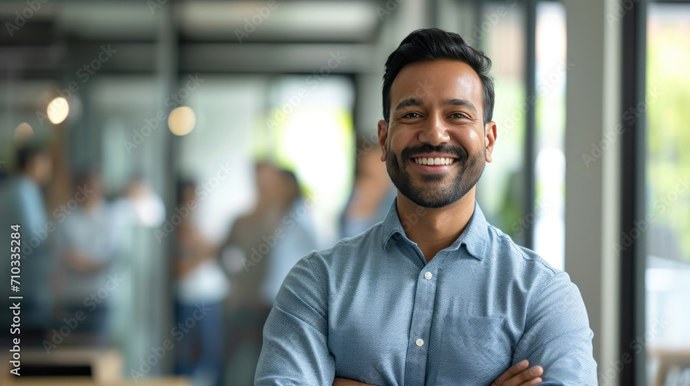 Portrait of a handsome smiling asian indian businessman boss standing in his modern business company office. Portrait of a handsome smiling asian indian businessman boss standing in his modern business company office.