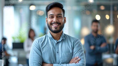 Portrait of a handsome smiling asian indian businessman boss standing in his modern business company office. © Farnaces