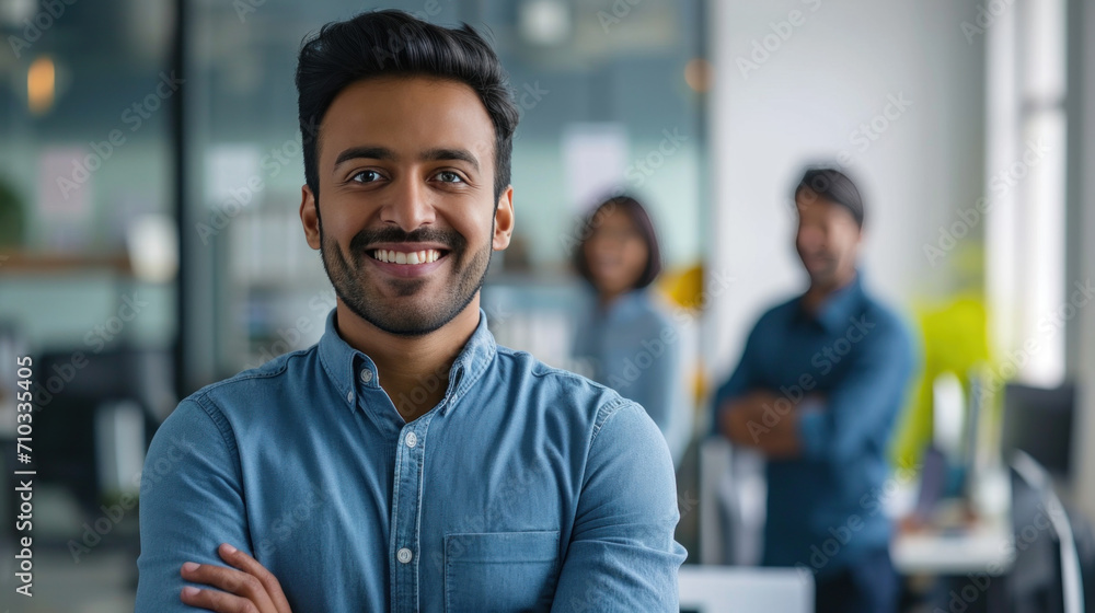 Portrait of a handsome smiling asian indian businessman boss standing in his modern business company office. Portrait of a handsome smiling asian indian businessman boss standing in his modern business company office.
