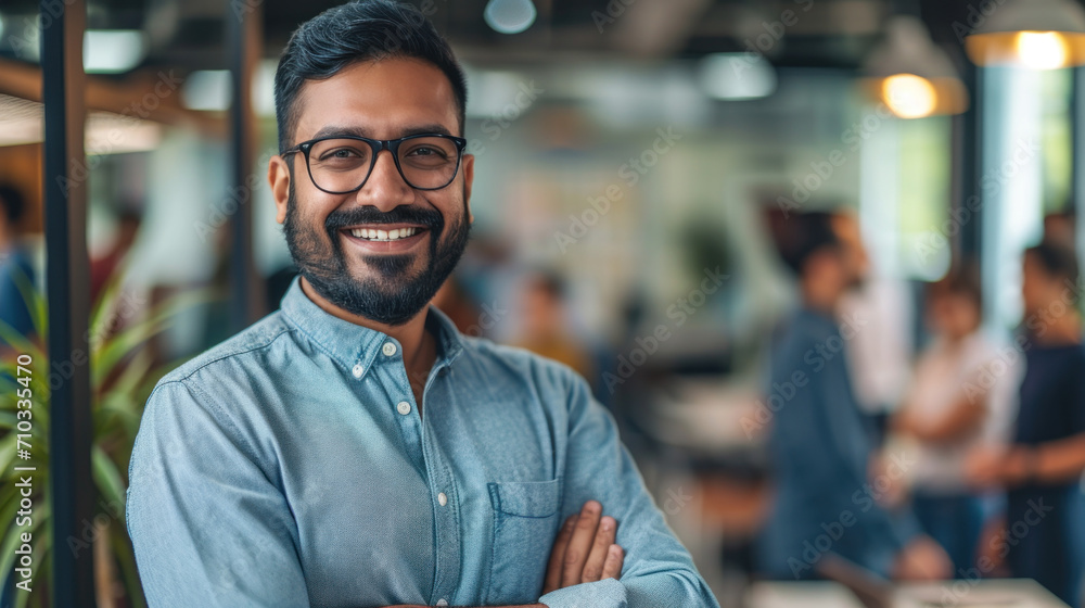 Portrait of a handsome smiling asian indian businessman boss standing in his modern business company office. Portrait of a handsome smiling asian indian businessman boss standing in his modern business company office.