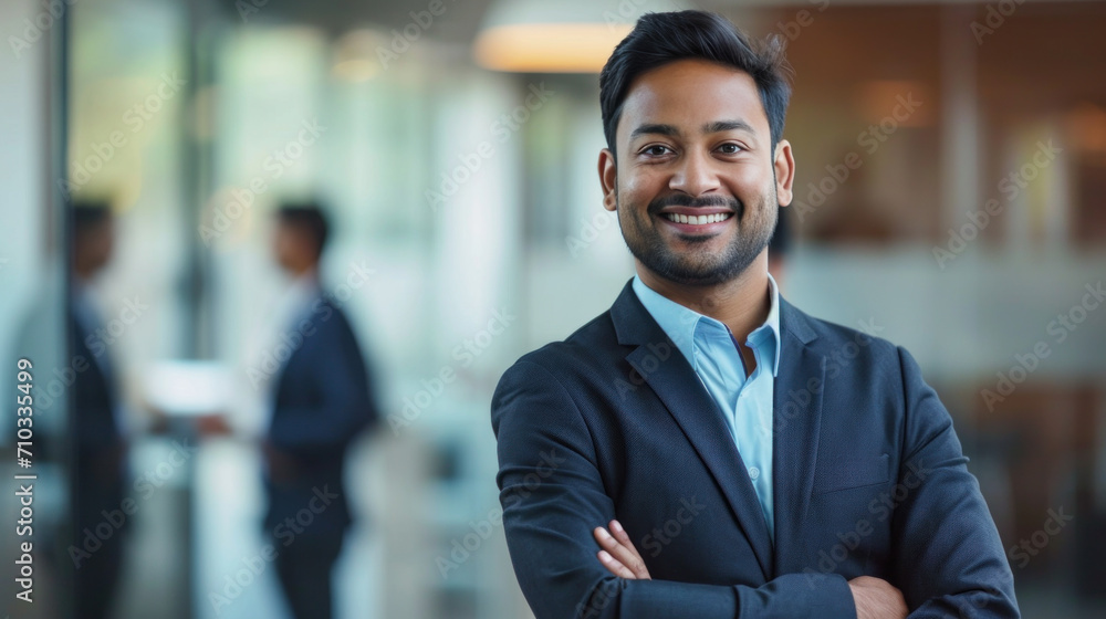 Portrait of a handsome smiling asian indian businessman boss standing in his modern business company office. Portrait of a handsome smiling asian indian businessman boss standing in his modern business company office.