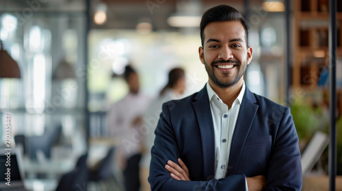 Portrait of a handsome smiling asian indian businessman boss standing in his modern business company office.