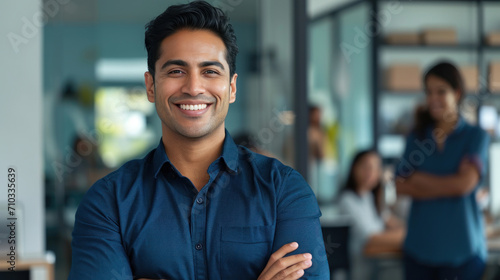 Portrait of a handsome smiling asian indian businessman boss standing in his modern business company office. photo