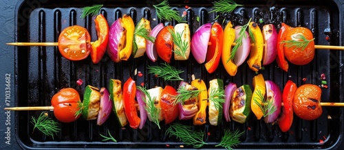 Vegetable skewers with tomatoes, radishes, peppers, onions, and dill on a grill pan.