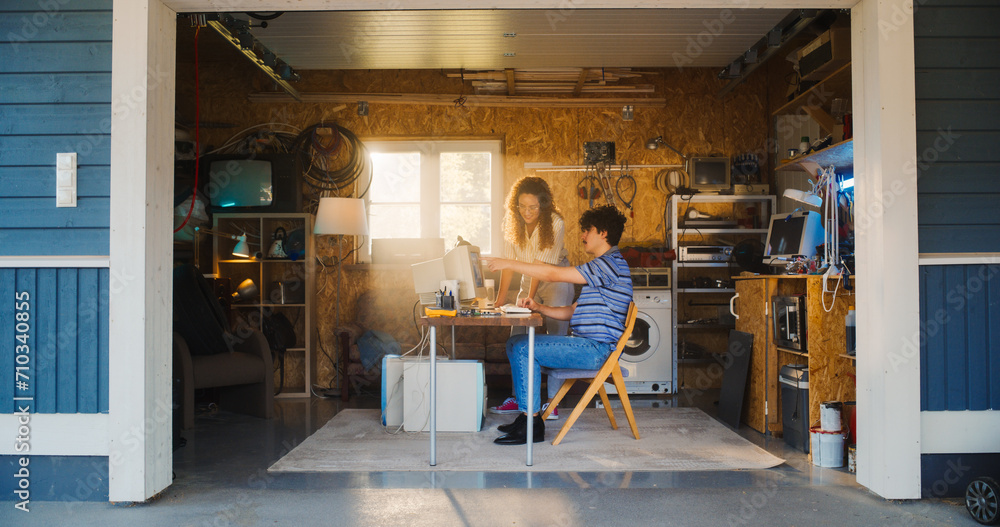 Caucasian Male Software Developer And Hispanic Female Designer Talking And Using Old Desktop Computer in Retro Garage. Diverse Startup Founders Working On Online Service In Nineties. Nostalgia Concept Caucasian Male Software Developer And Hispanic Female Designer Talking And Using Old Desktop Computer in Retro Garage. Diverse Startup Founders Working On Online Service In Nineties. Nostalgia Concept