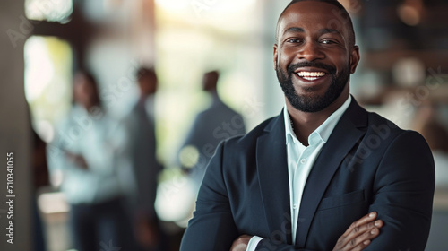 Portrait of a handsome smiling black businessman boss standing in his modern business company office.