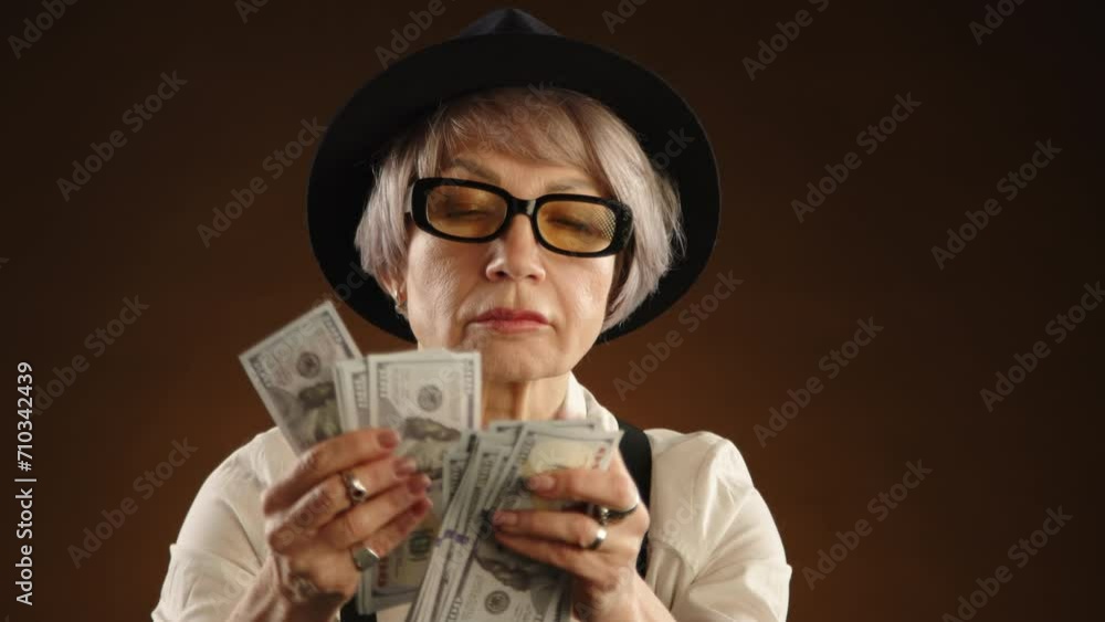 Elderly female poker champion relishes her victory, holding a substantial amount of cash winnings, reflecting her skill and luck at the card table. Camera 8K RAW. Elderly female poker champion relishes her victory, holding a substantial amount of cash winnings, reflecting her skill and luck at the card table. Camera 8K RAW.
