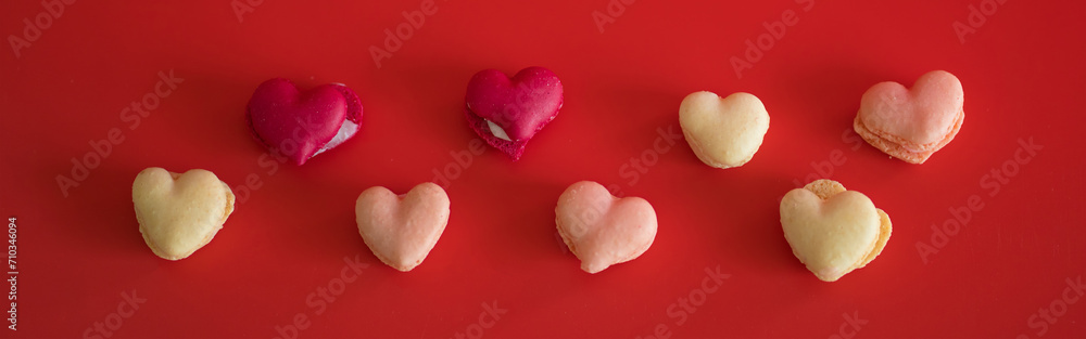 flat lay heart shape of macarons on red background