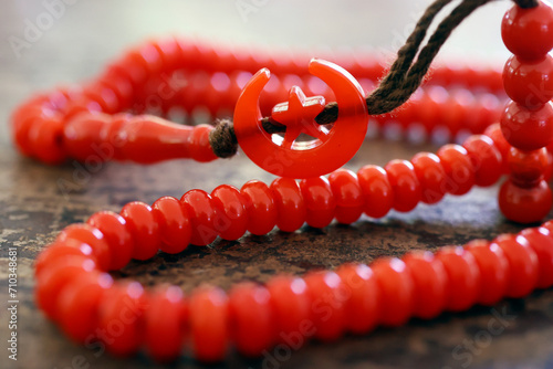 Red tasbih ( muslim prayer beads ) with star and crescent. Symbol of Islam. photo