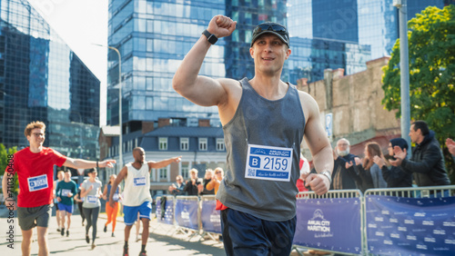 Portrait of Smiling Middle Aged Man Running in a City Marathon, Waving at the Supportive Audience. Friendly Happy Male Runner Celebrating Crossing the Finish Line in a Race