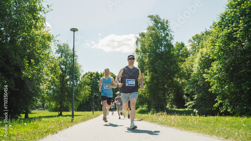 Portrait of a Group of People Participating Together in a Marathon and Running Through a Park Trail. Joggers Giving their Best to Achieve the Finish Line in a Friendly Race