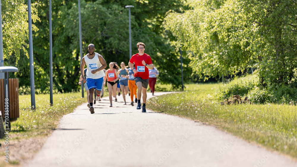 Wide Shot of Diverse Marathon Participants Competing in a Race for the Finish Line: Group of People Running Through Park Health Trail and Participating in a Marathon with Dedication Wide Shot of Diverse Marathon Participants Competing in a Race for the Finish Line: Group of People Running Through Park Health Trail and Participating in a Marathon with Dedication