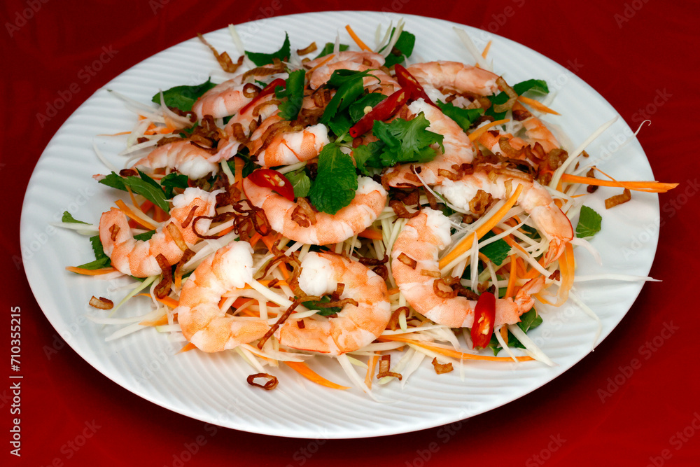 Plate of spicy Thai green papaya salad with prawns.