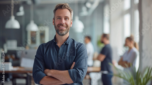 Portrait of a handsome smiling businessman boss standing in his modern business company office. © Farnaces