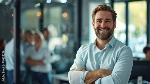 Portrait of a handsome smiling businessman boss standing in his modern business company office.