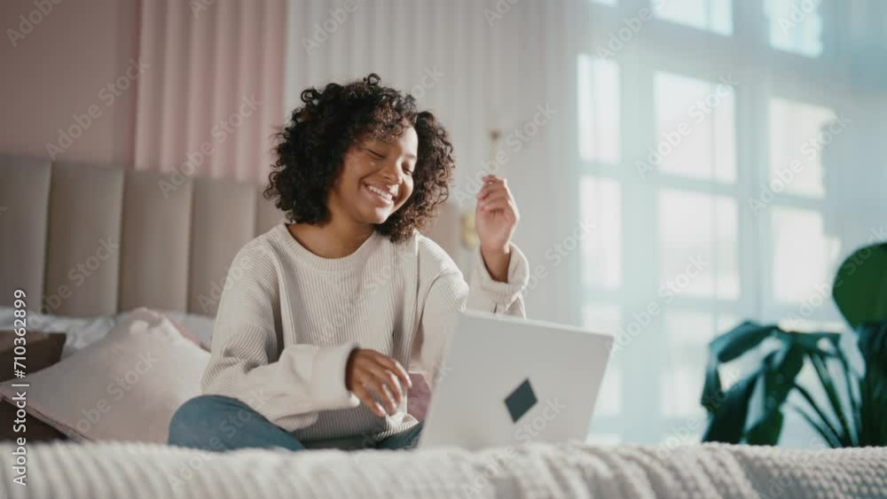 African american woman typing on laptop. Contented young girl typing messages on laptop chatting with friends sitting in bed at home. Smiling positive curly relaxed female enjoying communication. African american woman typing on laptop. Contented young girl typing messages on laptop chatting with friends sitting in bed at home. Smiling positive curly relaxed female enjoying communication.